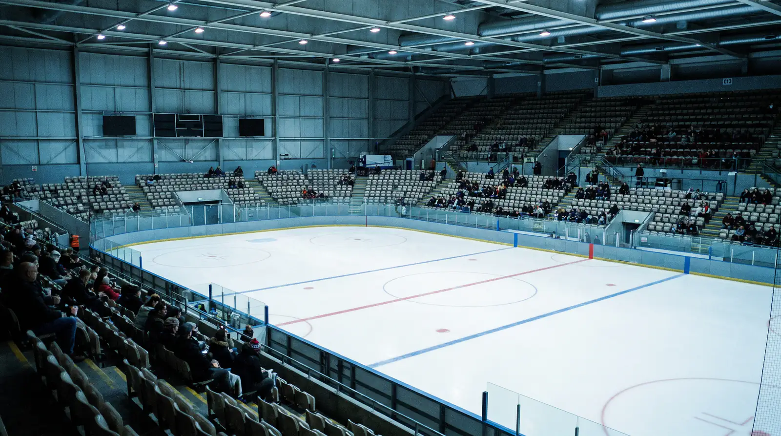 Half-empty British ice hockey arena seating bowl before a domestic game