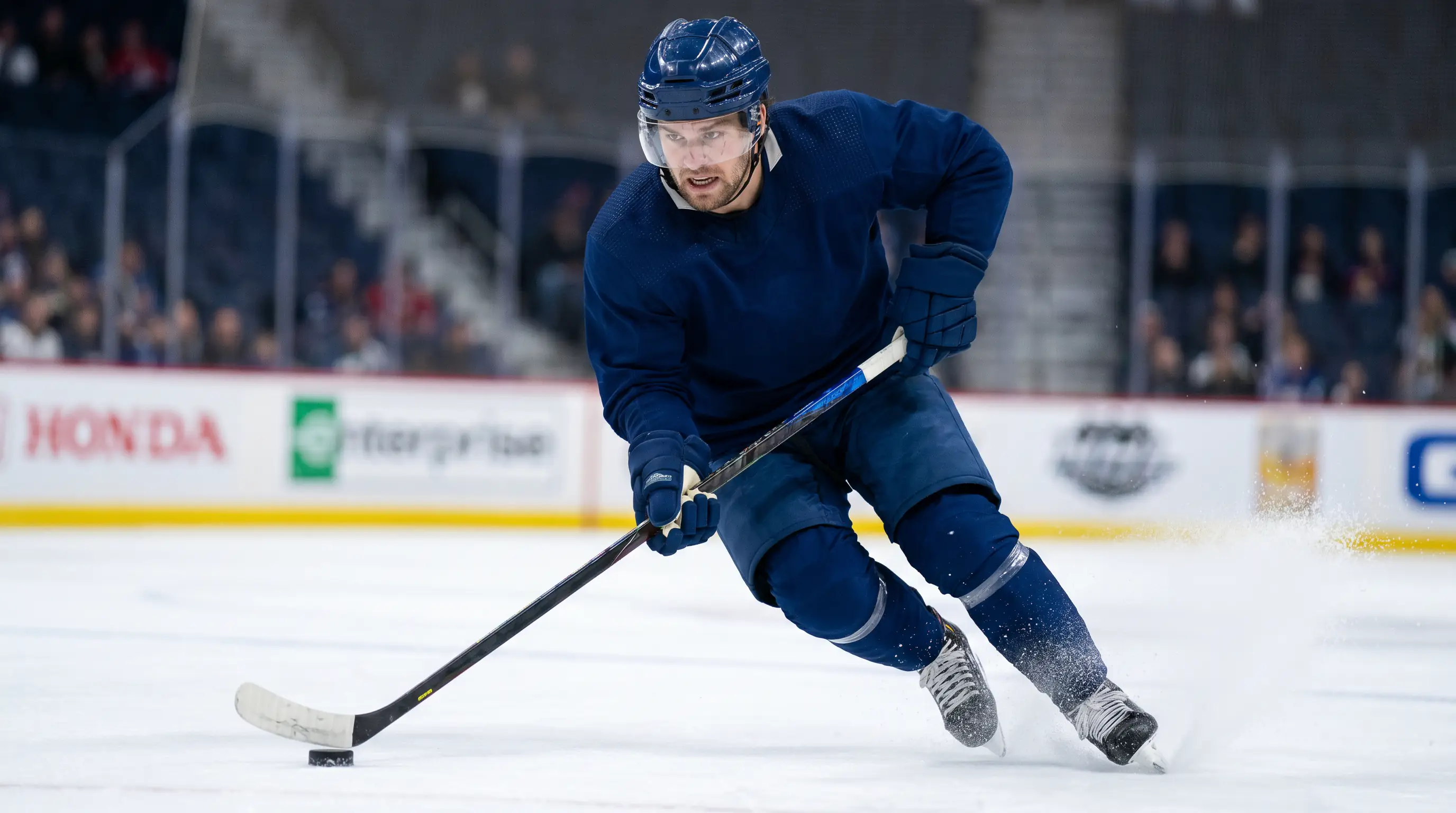 Elite NHL skater accelerating through the neutral zone with the puck