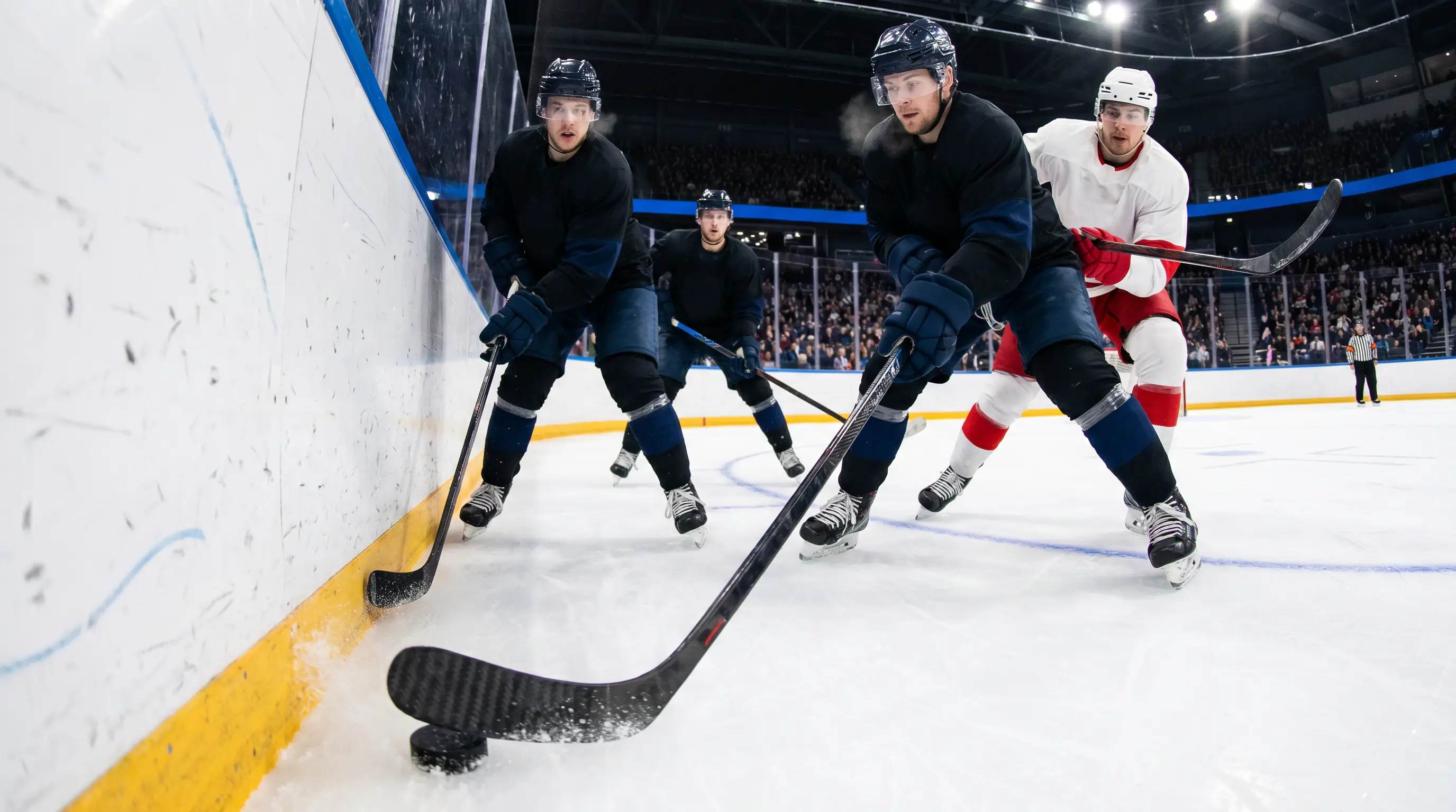 NHL forwards cycling the puck along the boards in the offensive zone