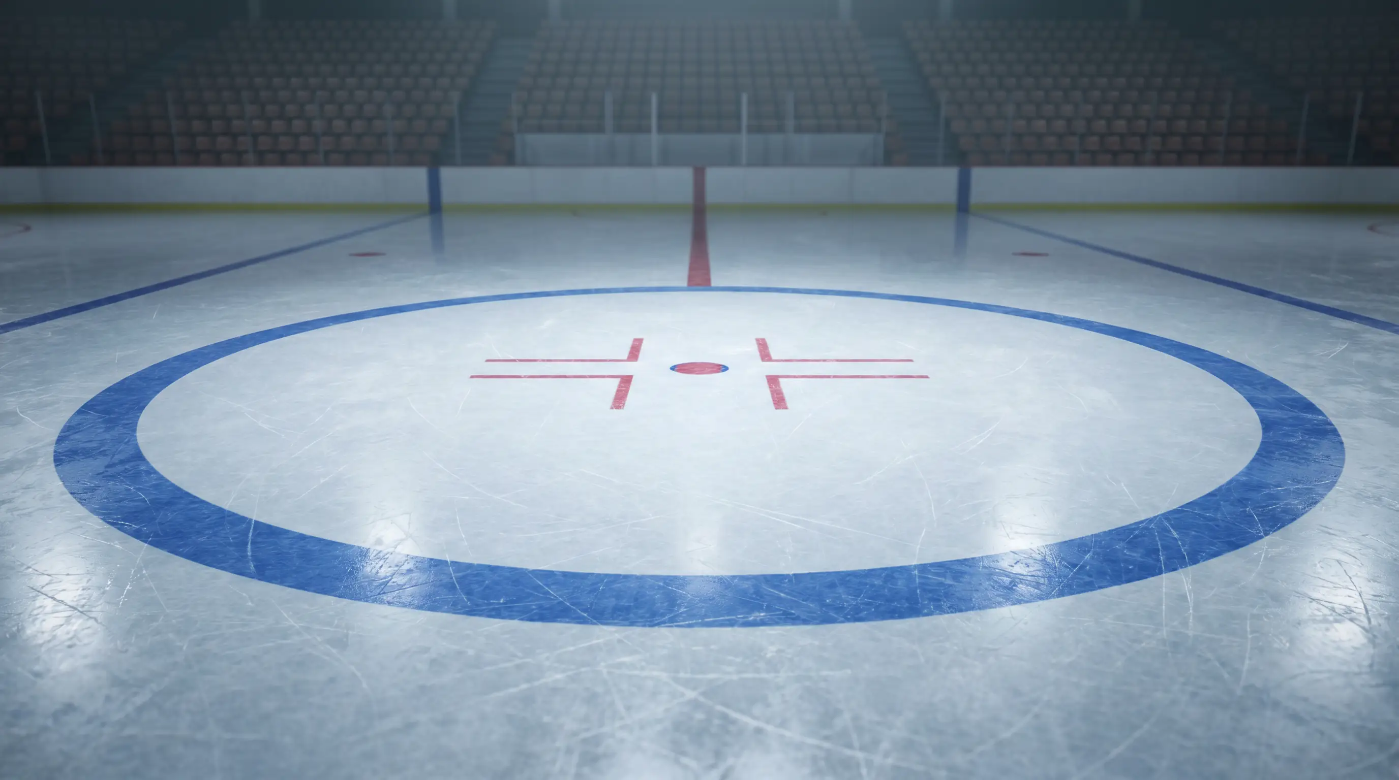 Centre-ice faceoff circle of an Olympic ice hockey rink under arena lights