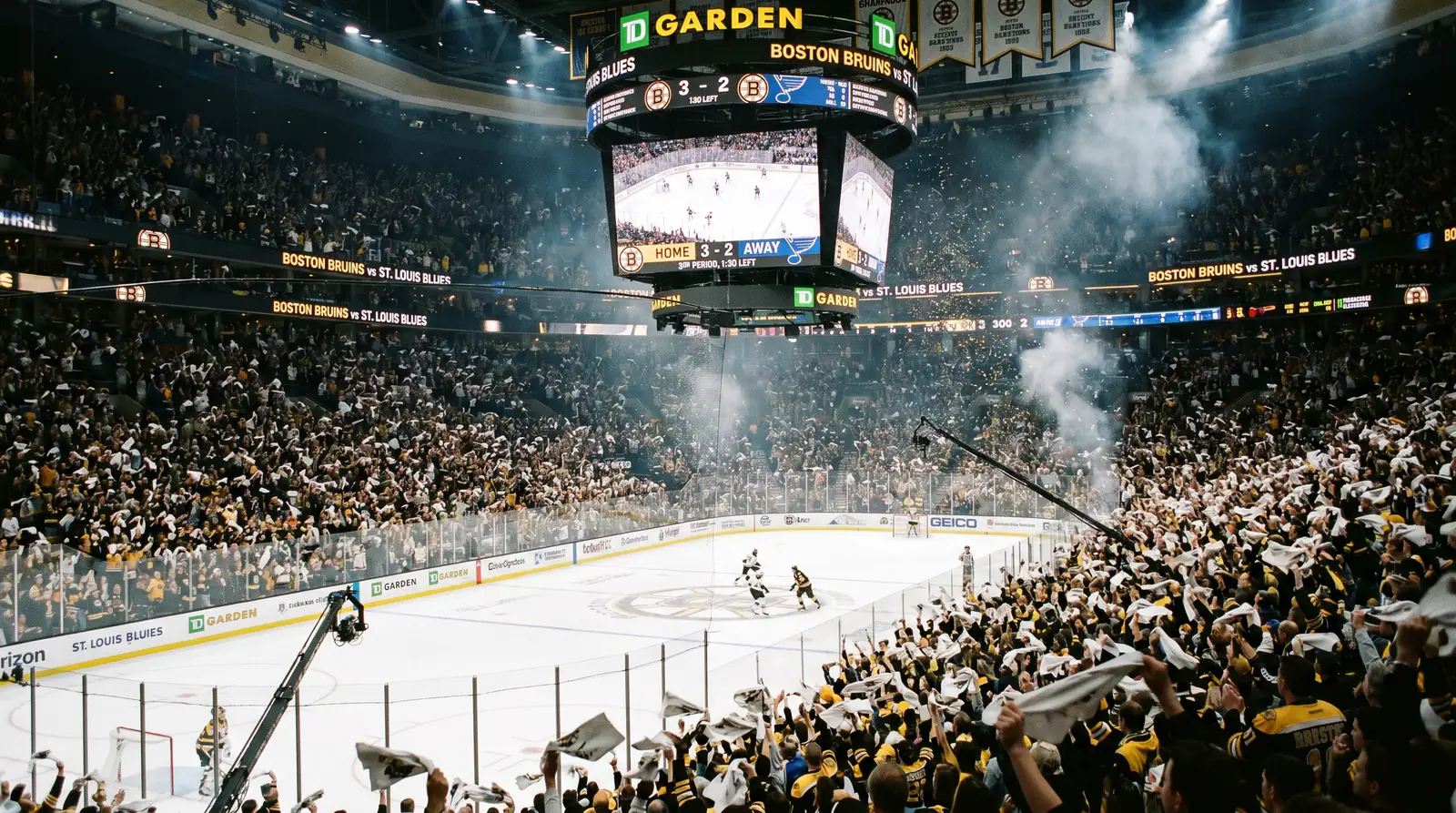 Home crowd at an NHL playoff game waving towels and standing through the action